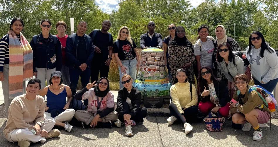 Fulbright Teachers pose for a group photo next to a bell