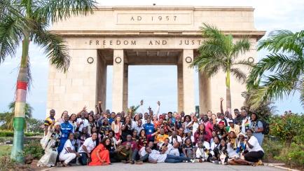group of teachers standing outside of Black Star Square in Ghana