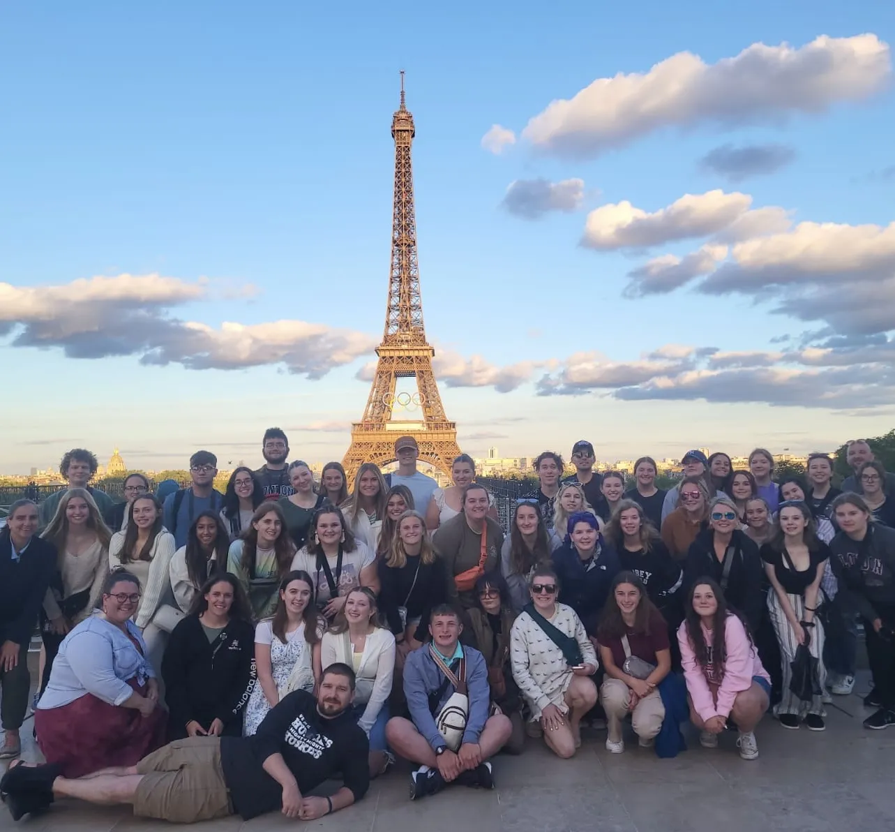 a group of students and teachers at the Eiffel Tower